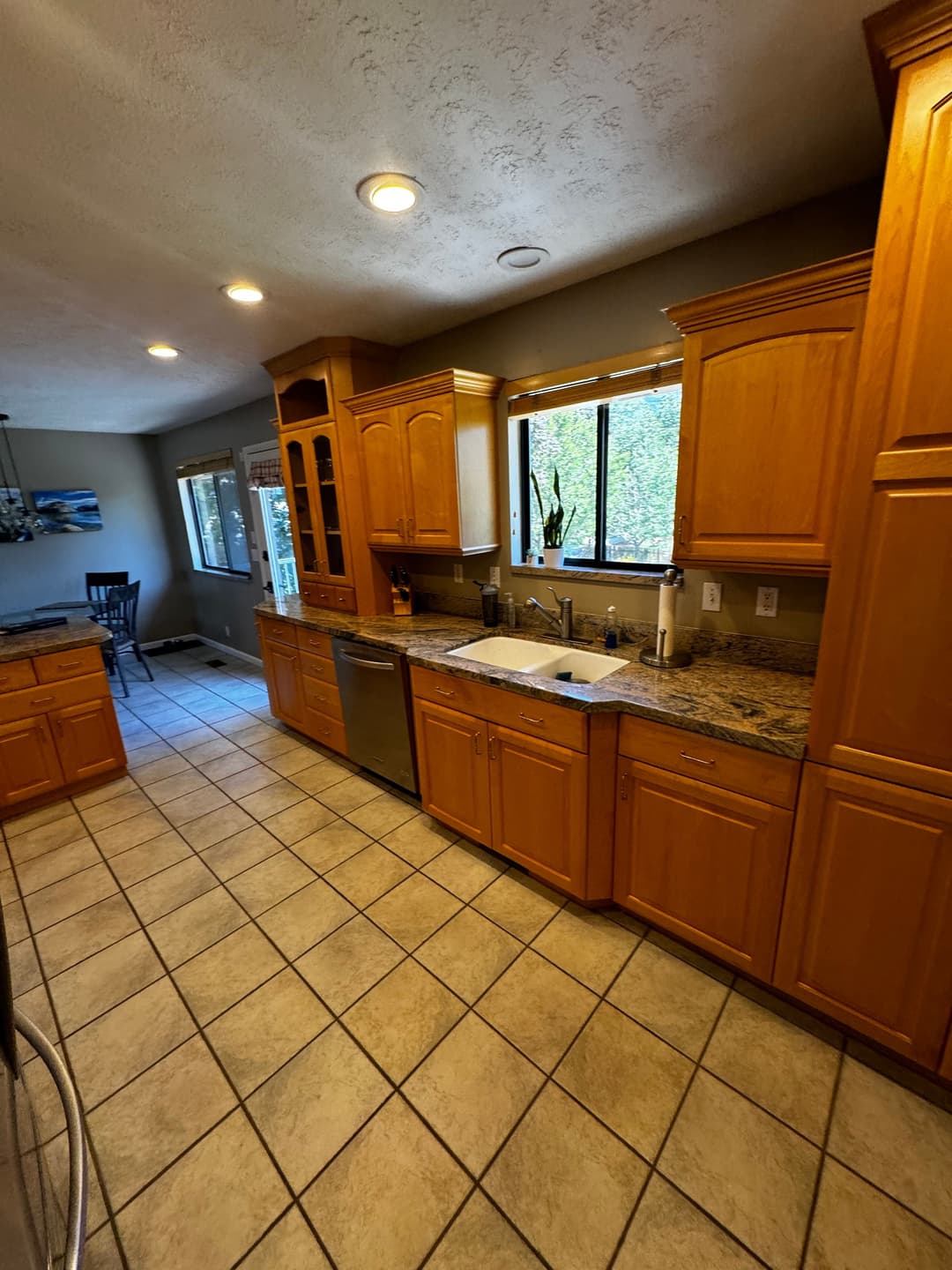 Modern kitchen featuring wooden cabinets, granite countertops, and bright natural light.