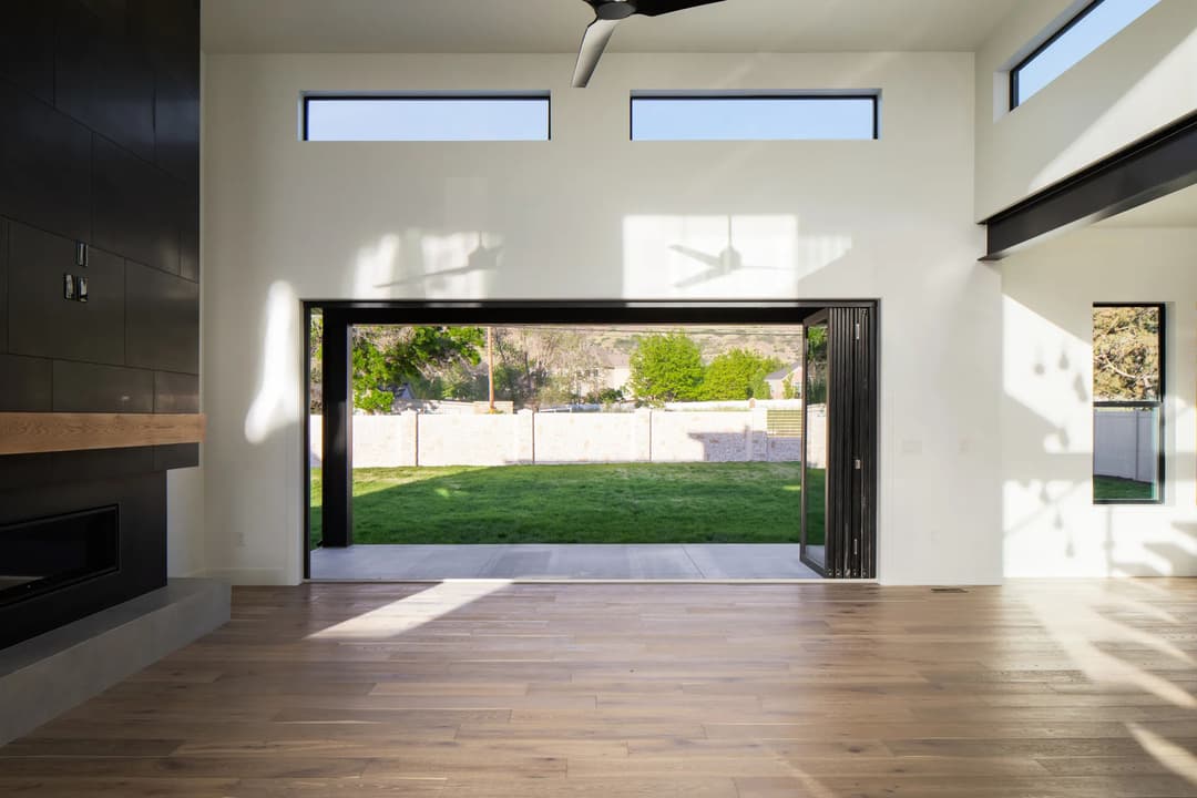 Modern living room with large sliding doors opening to a green backyard and natural light.