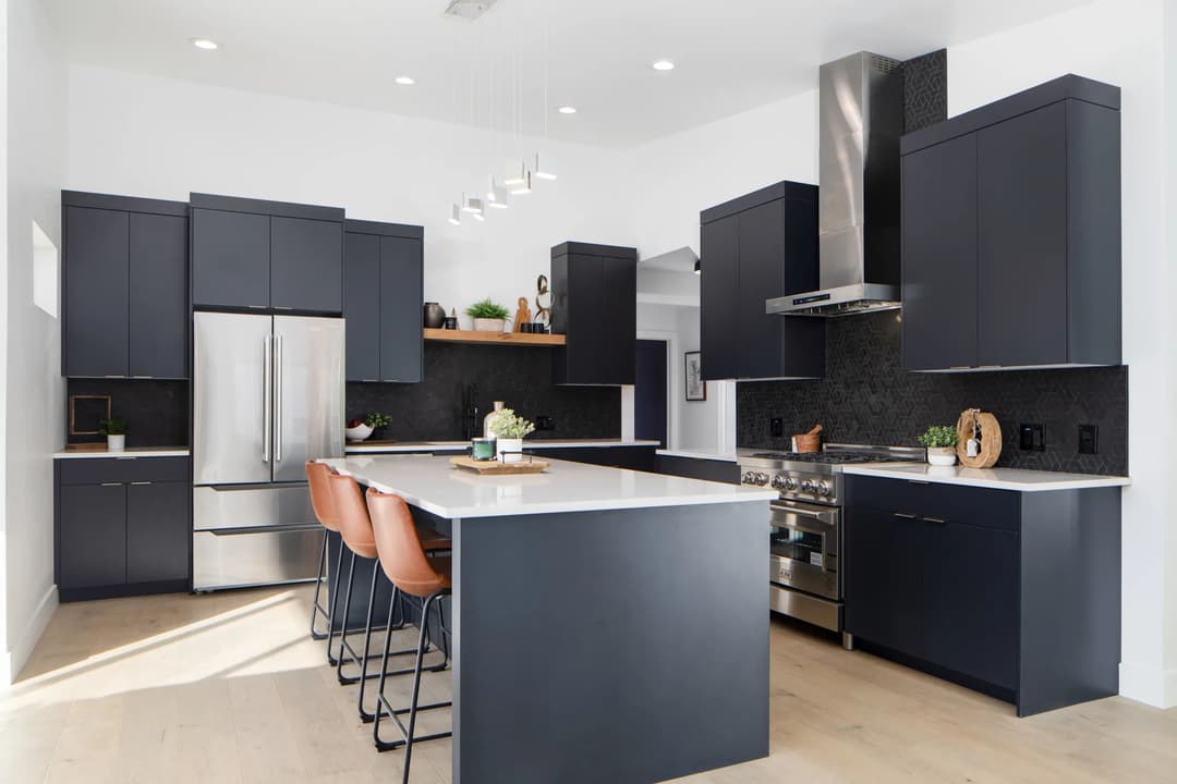 Modern kitchen with black cabinetry, stainless steel appliances, and a large island with seating.